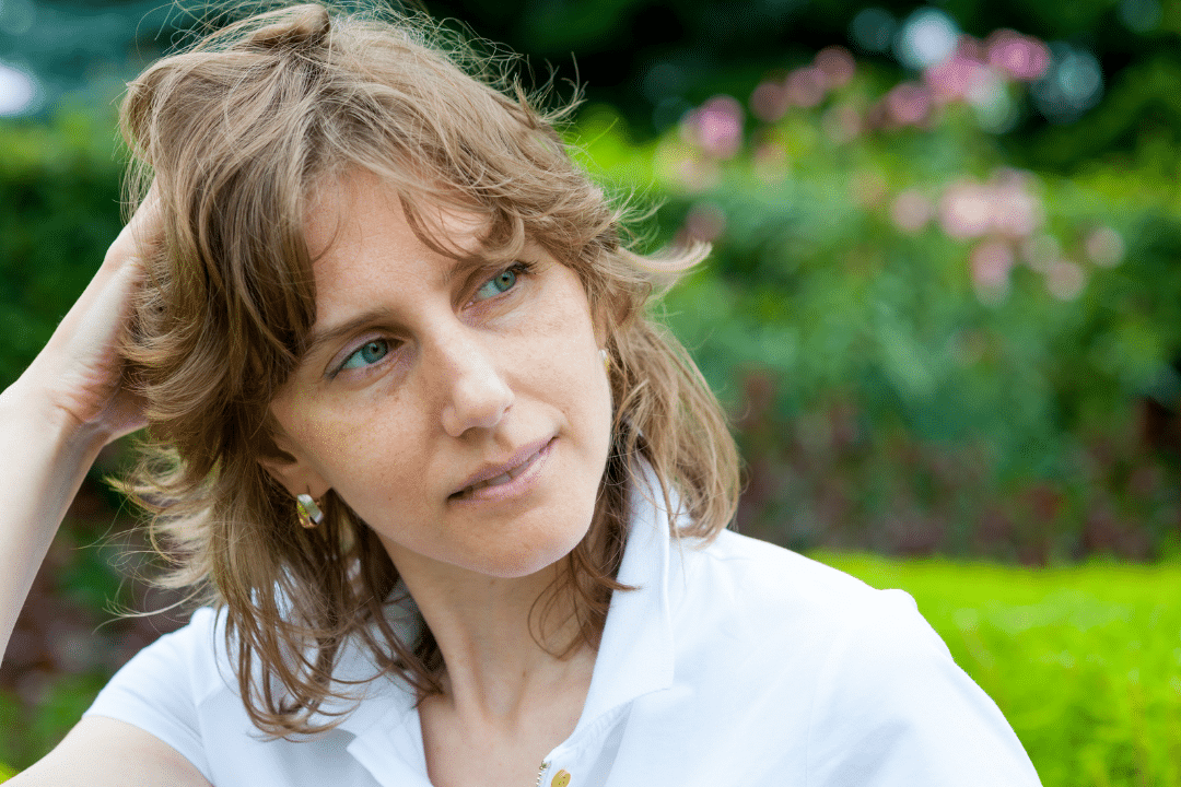 kvinna kliar sig i håret