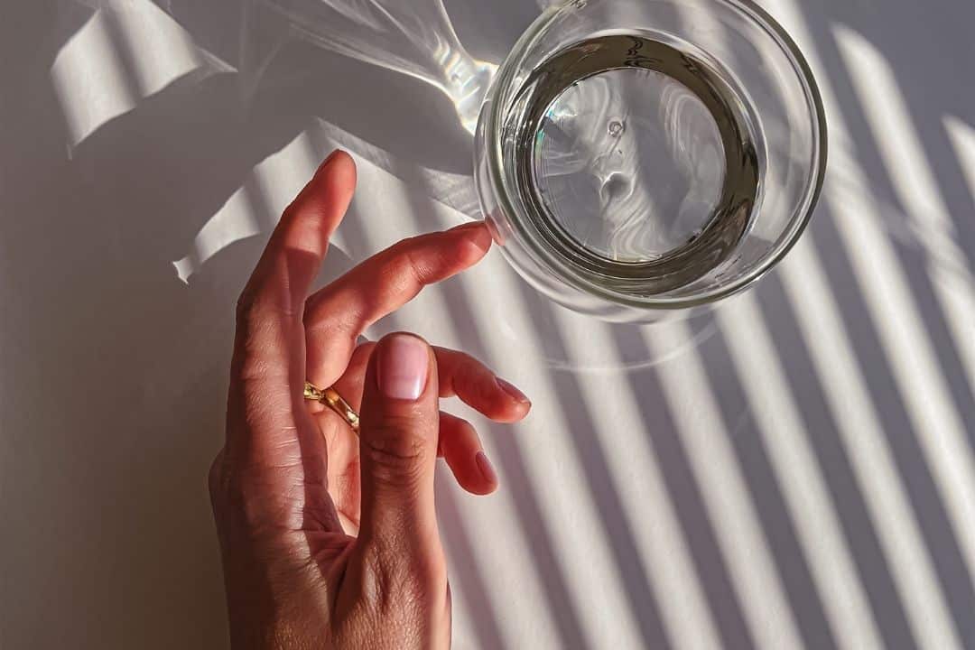 Hand med ett glas vatten